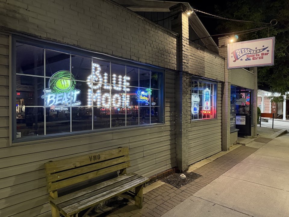 Wood-paneled sports bar with mounted screens.